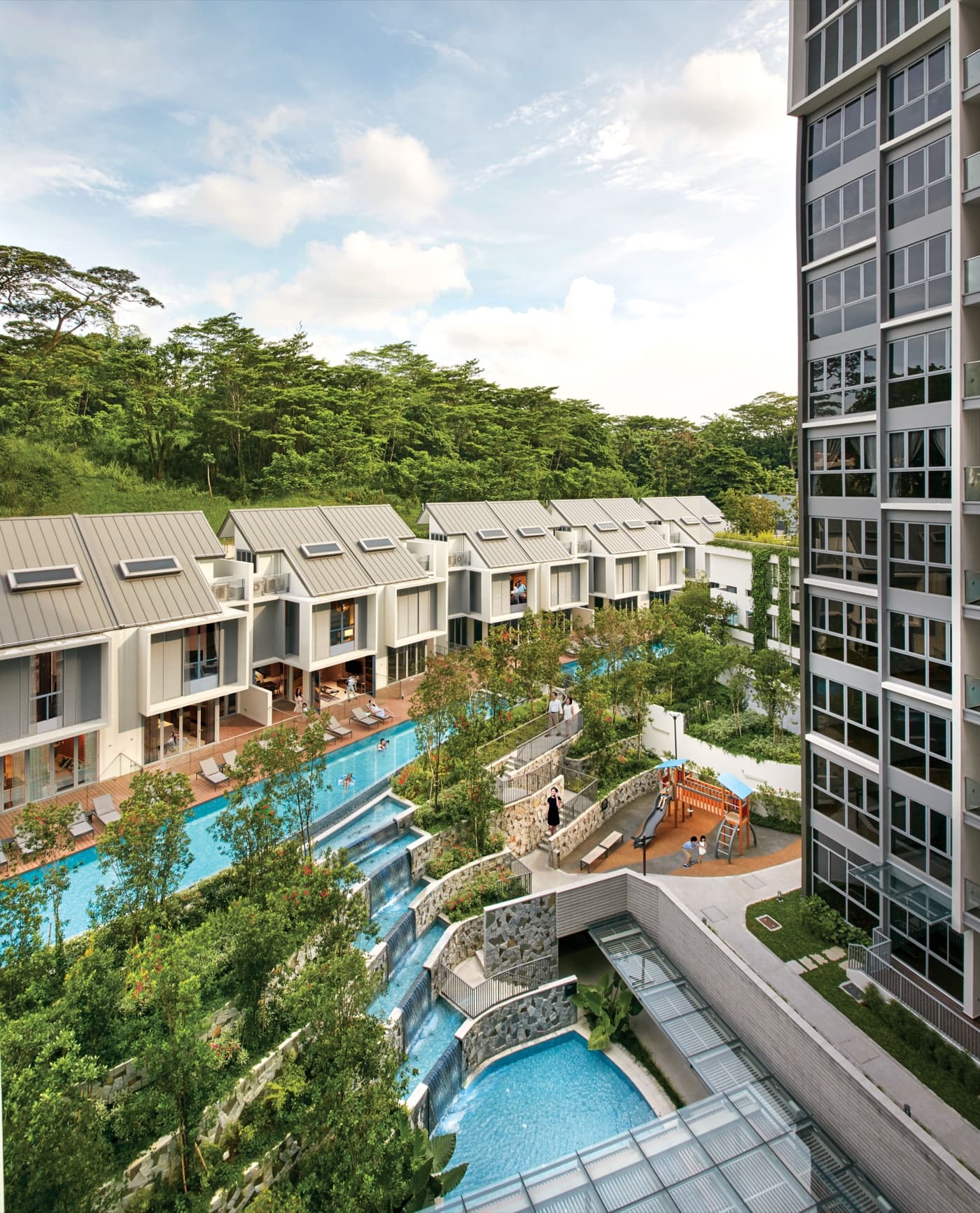 Townhouse development with strata-titled landed units alongside a condo tower, with shared pool and landscaping